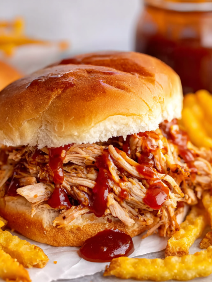 A sandwich with pulled pork and barbecue sauce.