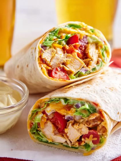 A Southwest Chicken Wrap with lettuce and tomatoes.