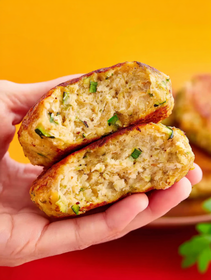 A person is holding two chicken patties.