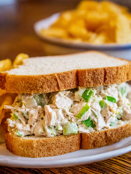 A sandwich with tuna salad on a plate.