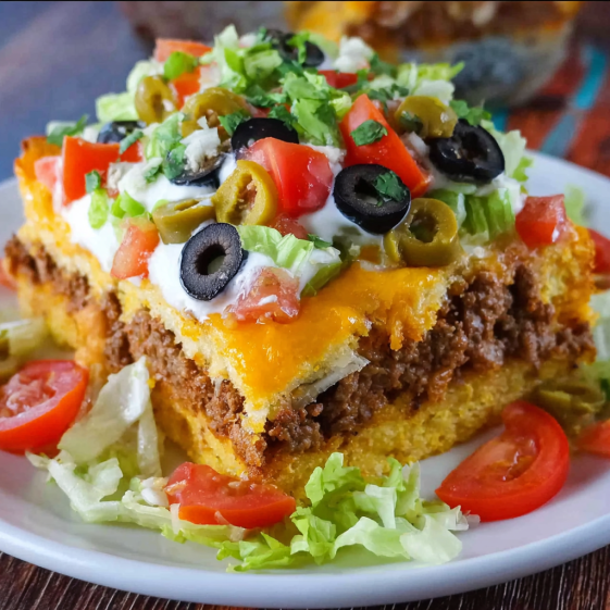 A plate of food with a cornbread taco bake.
