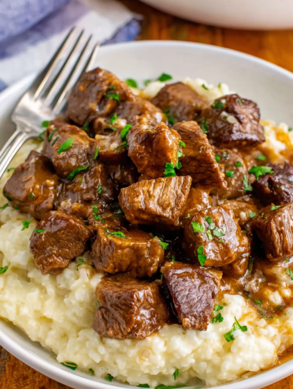 A plate of beef steak with gravy.