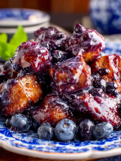 A plate of food with blueberries on top.