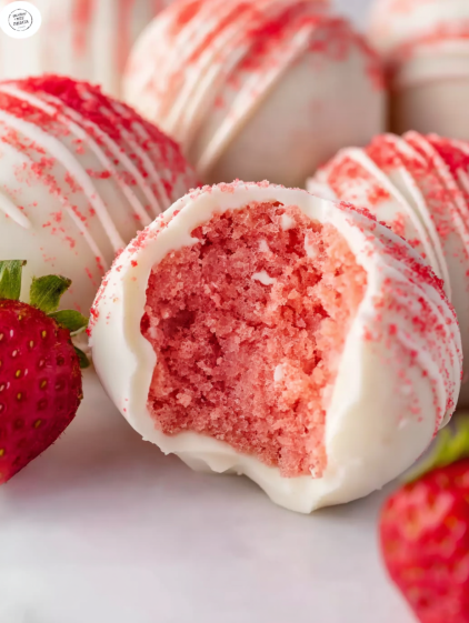 A close up of a cake ball with red and white icing.