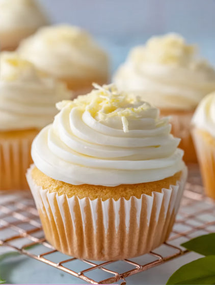 A cupcake with white frosting and yellow sprinkles.