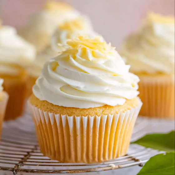 A cupcake with white frosting and yellow sprinkles.