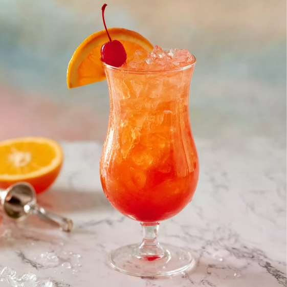 A glass of a hurricane drink with a cherry on top.