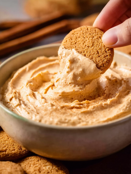 A person is scooping a pumpkin pie dip.