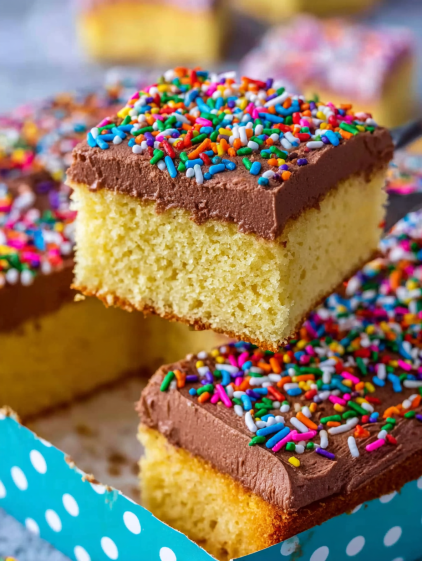 A slice of homemade yellow cake with chocolate frosting.