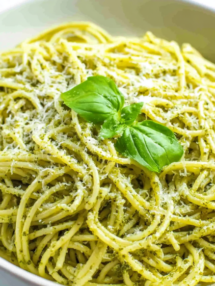 A bowl of pasta with a green leaf on top.