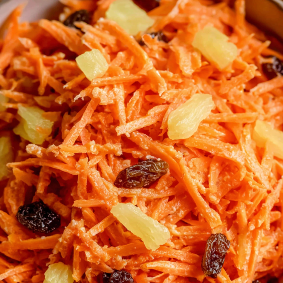 A bowl of carrot salad with raisins.