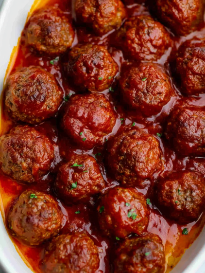 A plate of meatballs in a red sauce.