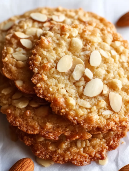 A stack of cookies with almonds on top.