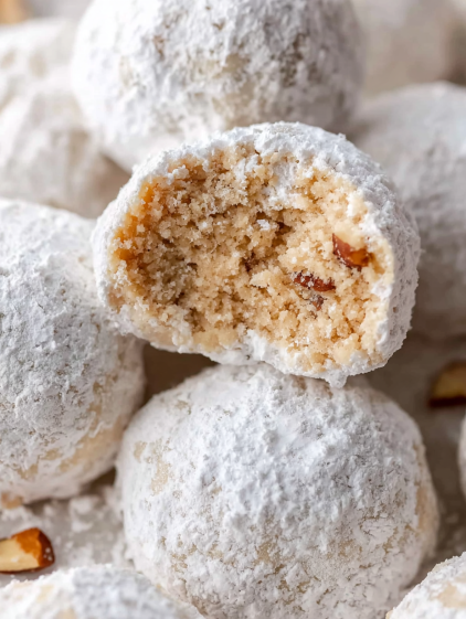 Snowball cookies with a bite taken out of them.