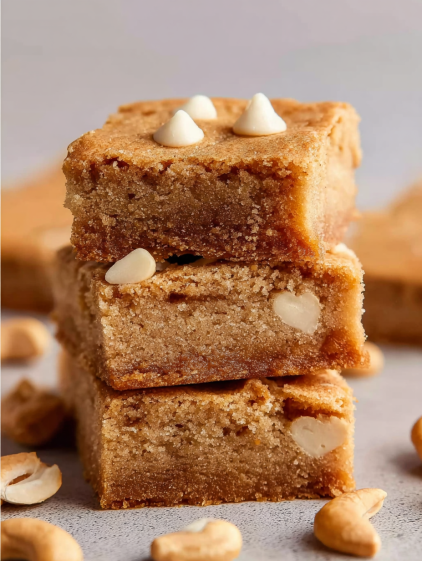 Three pieces of blondies with white chocolate on top.