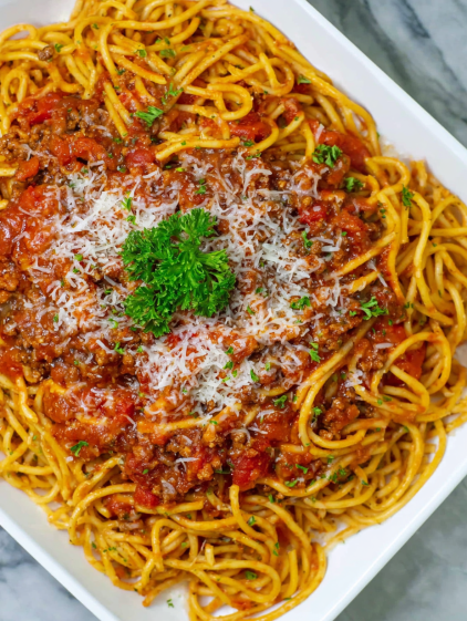 A bowl of spaghetti with meat sauce and cheese.