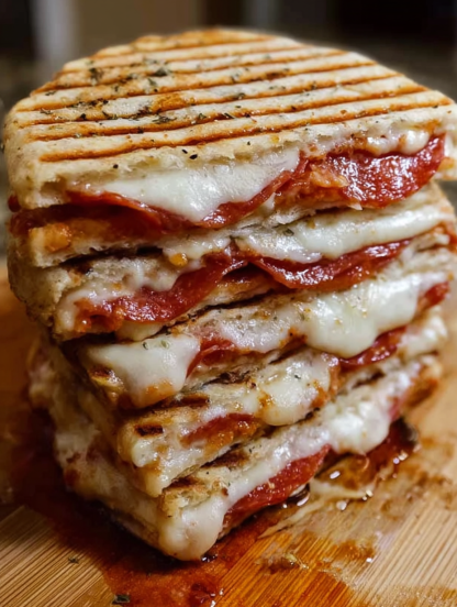 A stack of sandwiches with cheese and tomato sauce.