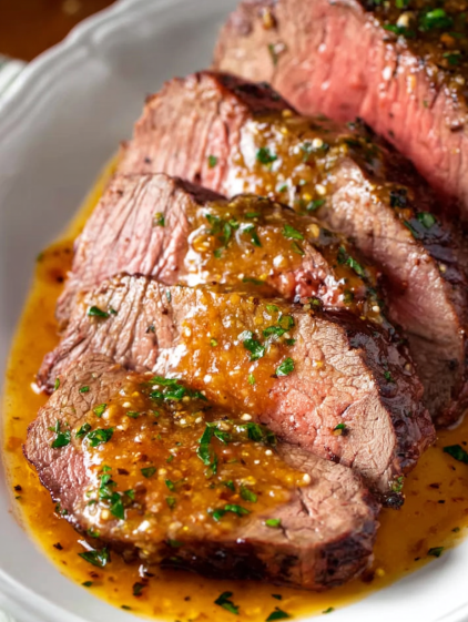 A close up of a piece of meat with a sauce on it.