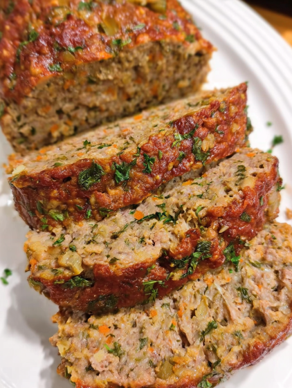 A stack of meat with vegetables on top.