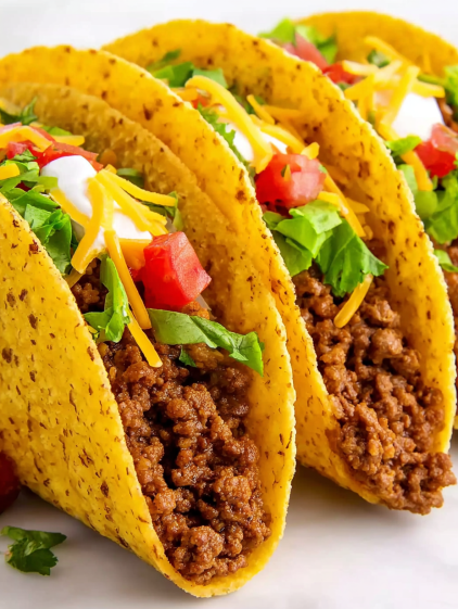 A plate of tacos with tomatoes and cheese.