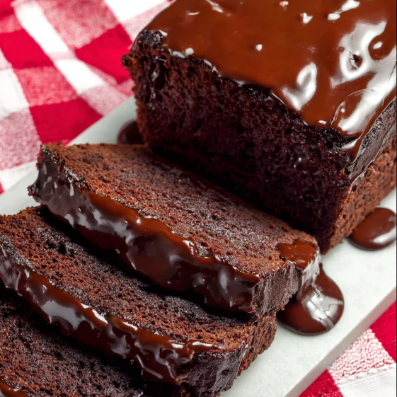 A slice of chocolate cake with chocolate sauce drizzled on top.