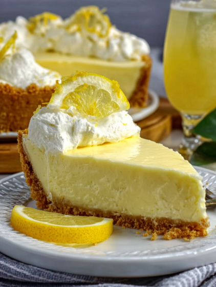 A slice of cheesecake with a lemon wedge on top.