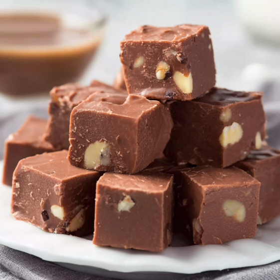 A stack of chocolate squares with nuts on top.