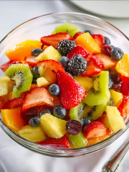 A bowl of fruit with kiwi, strawberries, blueberries, and blackberries.