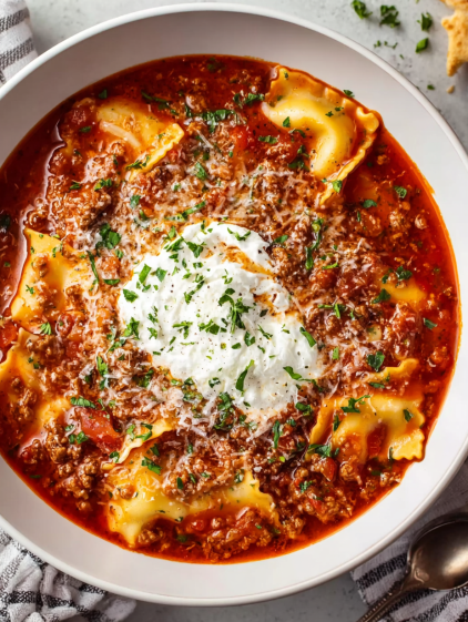 A bowl of pasta with meat sauce and white cheese.