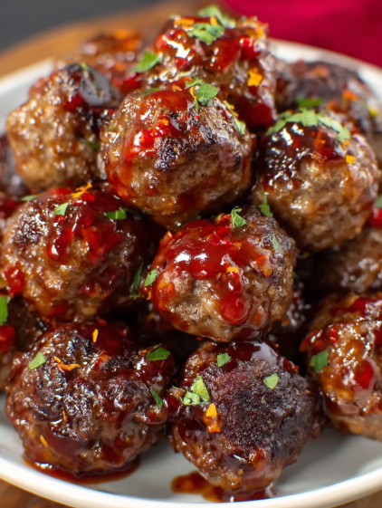 A plate of meatballs with sauce.