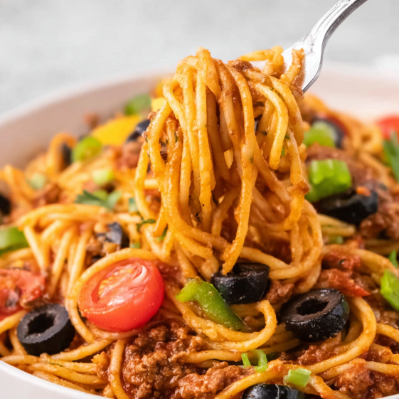 A bowl of spaghetti with meat and vegetables.
