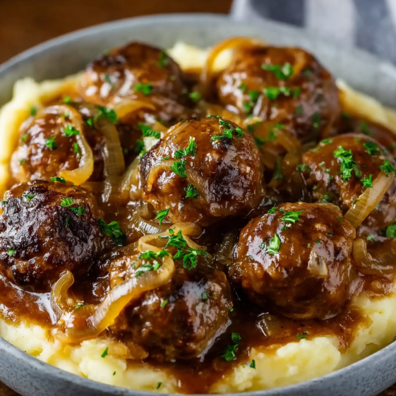 A plate of meatballs covered in a brown sauce.