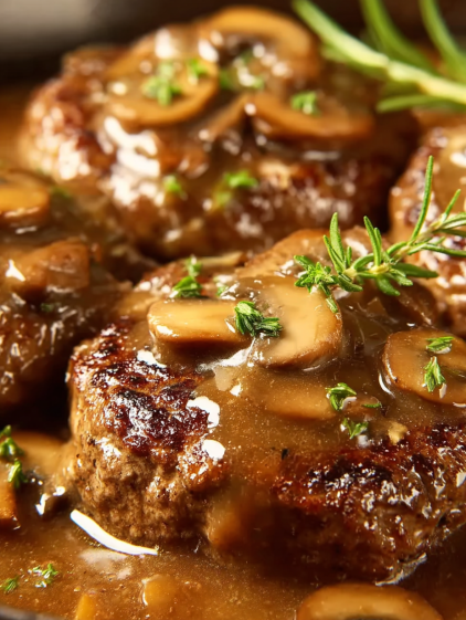 Meat covered in gravy and mushrooms.