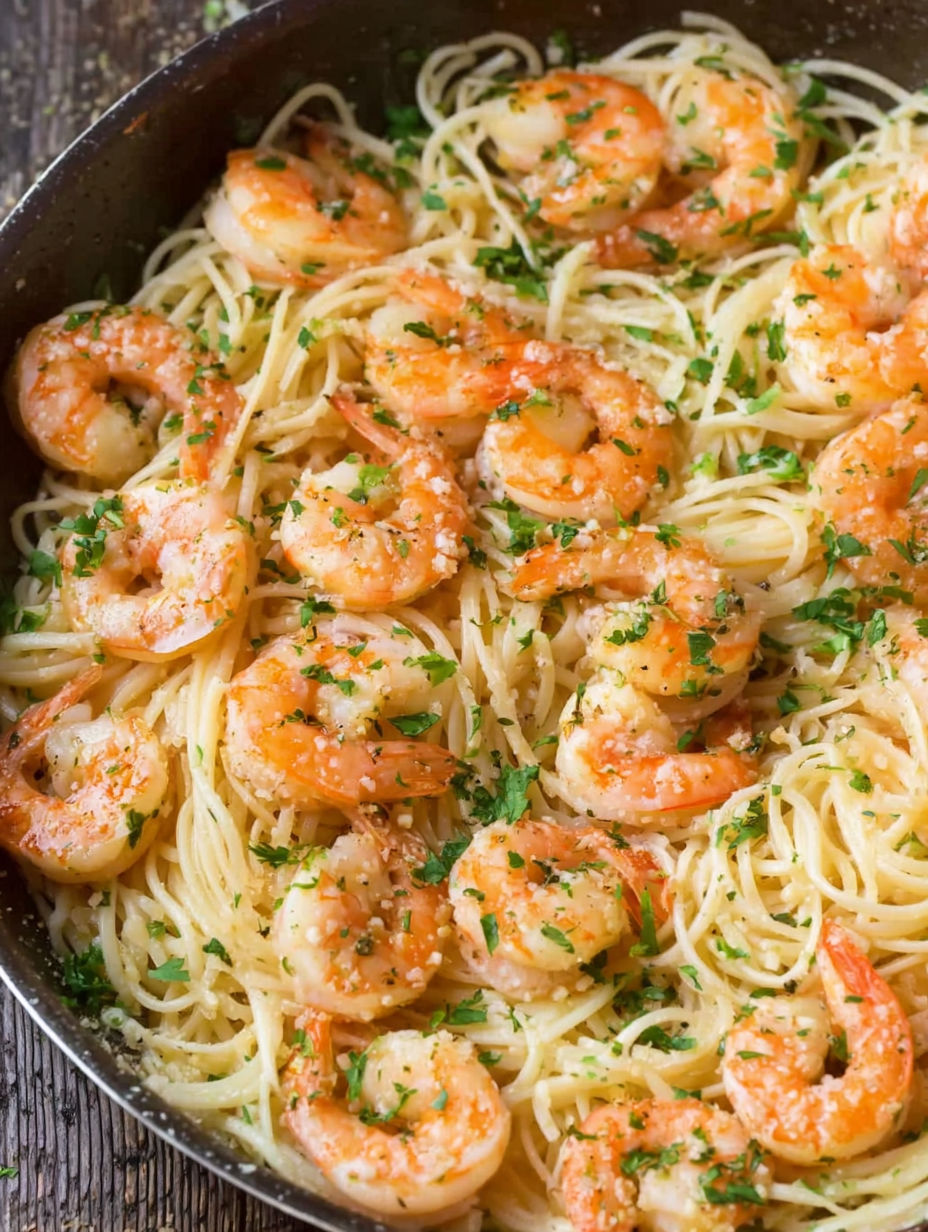 A plate of shrimp scampi with pasta.