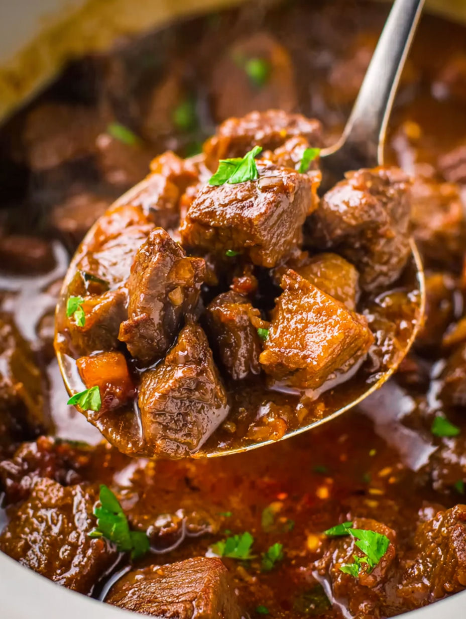 A spoonful of beef stew in a crockpot.