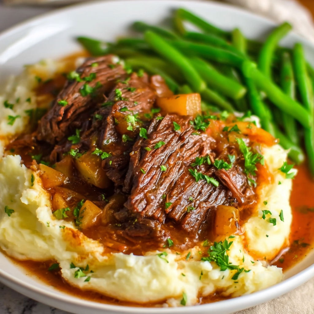 A plate of food with a pot roast and green beans.