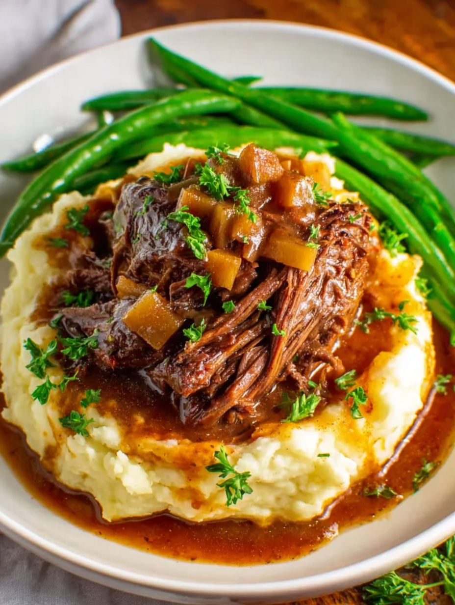 A plate of food with a pot roast and green beans.