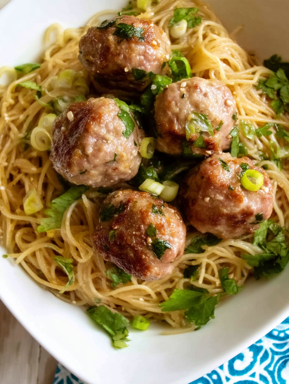 A bowl of Asian meatballs with noodles.