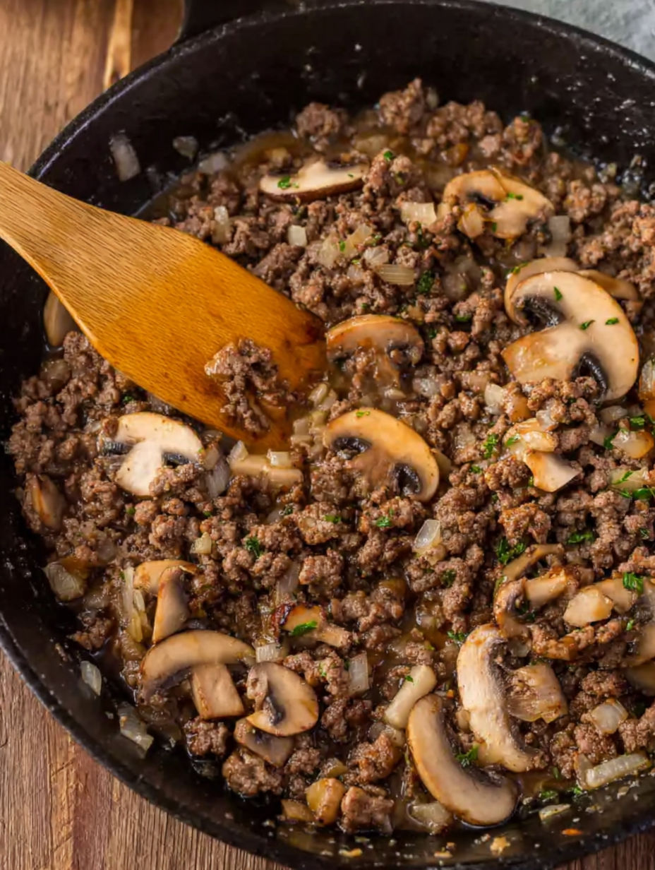 A bowl of Salisbury steak with mushrooms and onions.