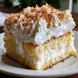 A slice of coconut cloud cake on a plate.