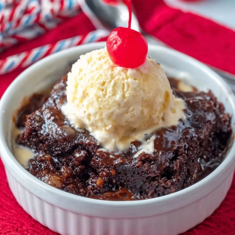 A bowl of chocolate cake with a scoop of ice cream on top.