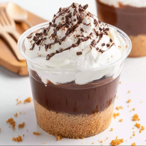 A cup of chocolate parfait with whipped cream.