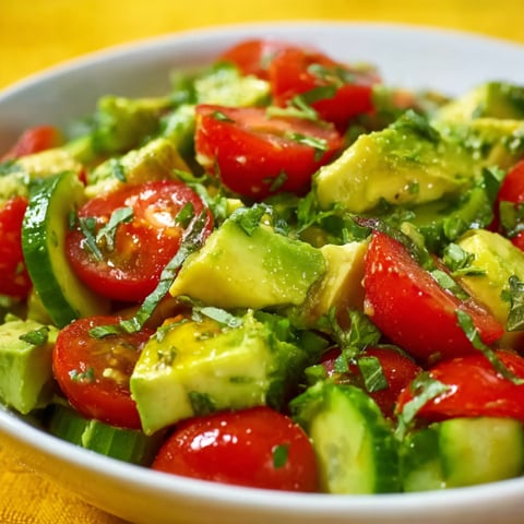 A bowl of cucumber, tomato, and avocado salad.