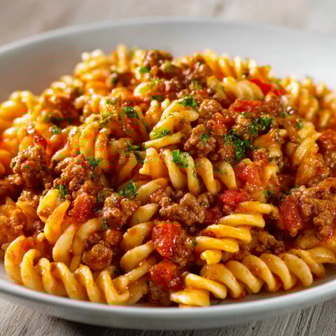 A plate of pasta with meat sauce and tomato sauce.