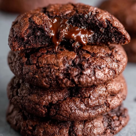 A stack of chocolate cookies with chocolate drizzle.