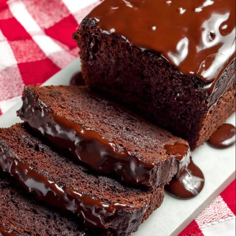 A slice of chocolate cake with chocolate sauce drizzled on top.