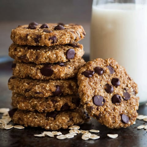 A stack of chocolate chip cookies with milk.