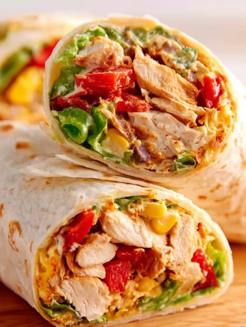 Two Southwest Chicken Wraps with lettuce, tomatoes, and corn.