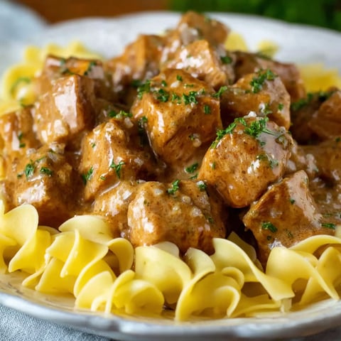 A plate of pork bites with gravy.