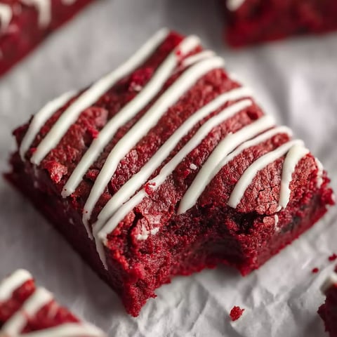 A piece of red velvet cake with white icing.